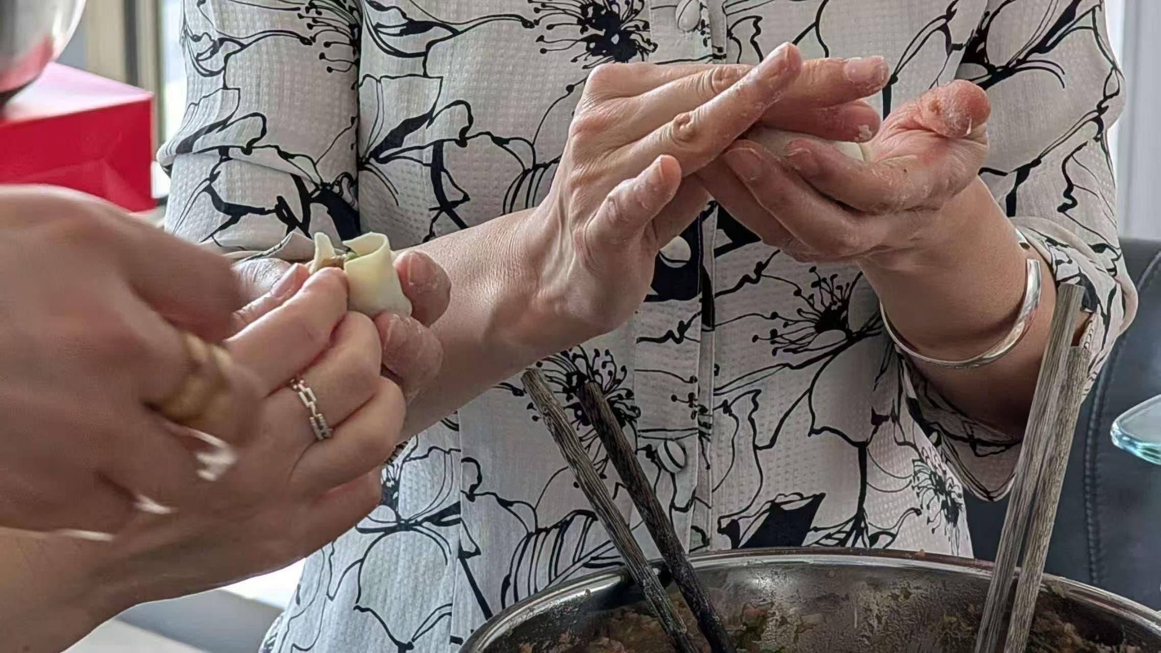 image of people wrapping dumplings